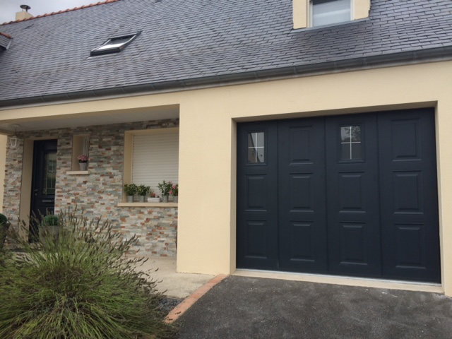 Porte de garage latérale grise RAL 7016 installée sur une maison traditionnelle.