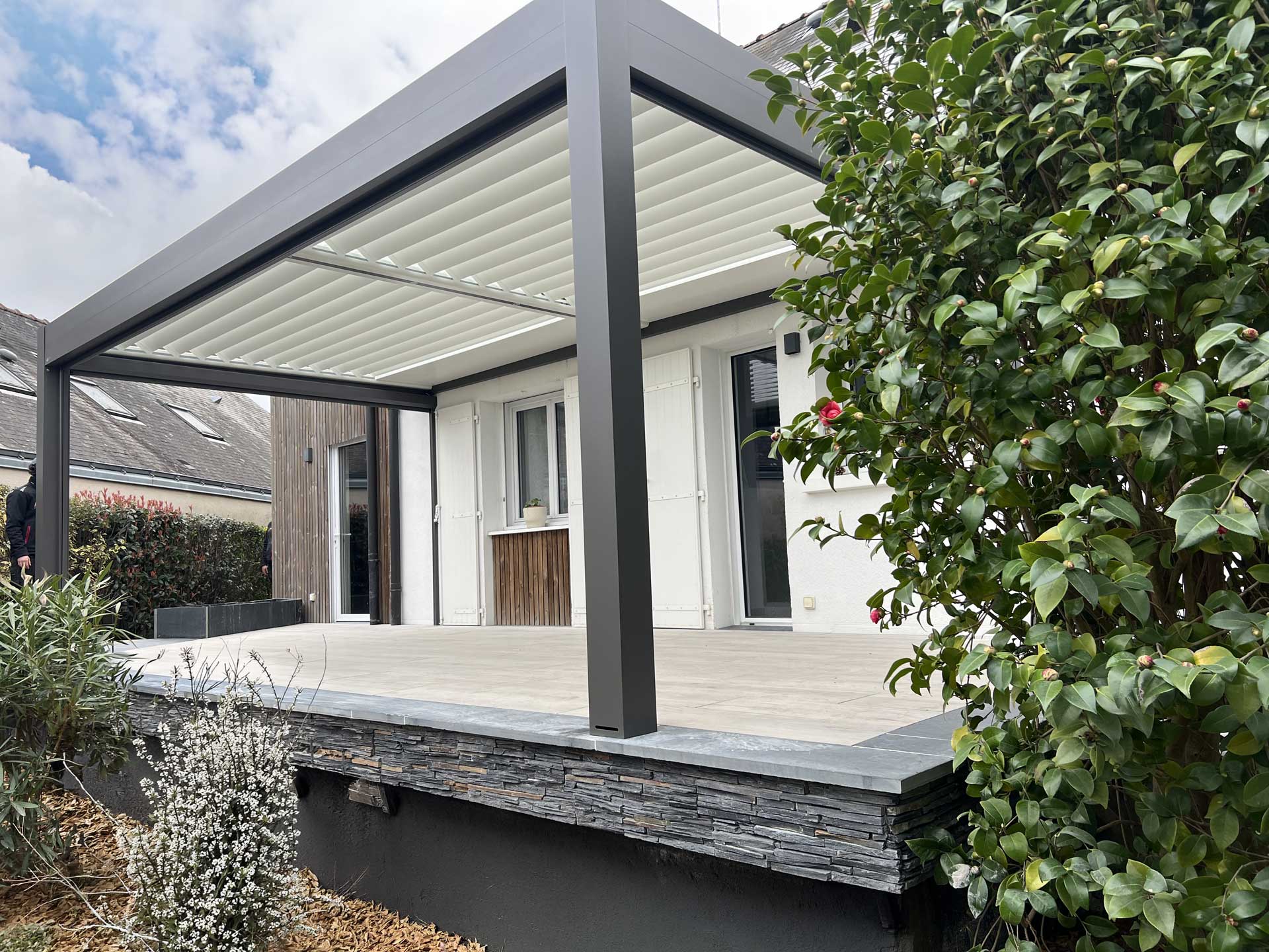 Pergola bioclimatique en aluminium anthracite installée sur terrasse surélevée par Levron Menuiserie en Maine-et-Loire Pergola bioclimatique en aluminium anthracite installée sur terrasse surélevée par Levron Menuiserie en Maine-et-Loire