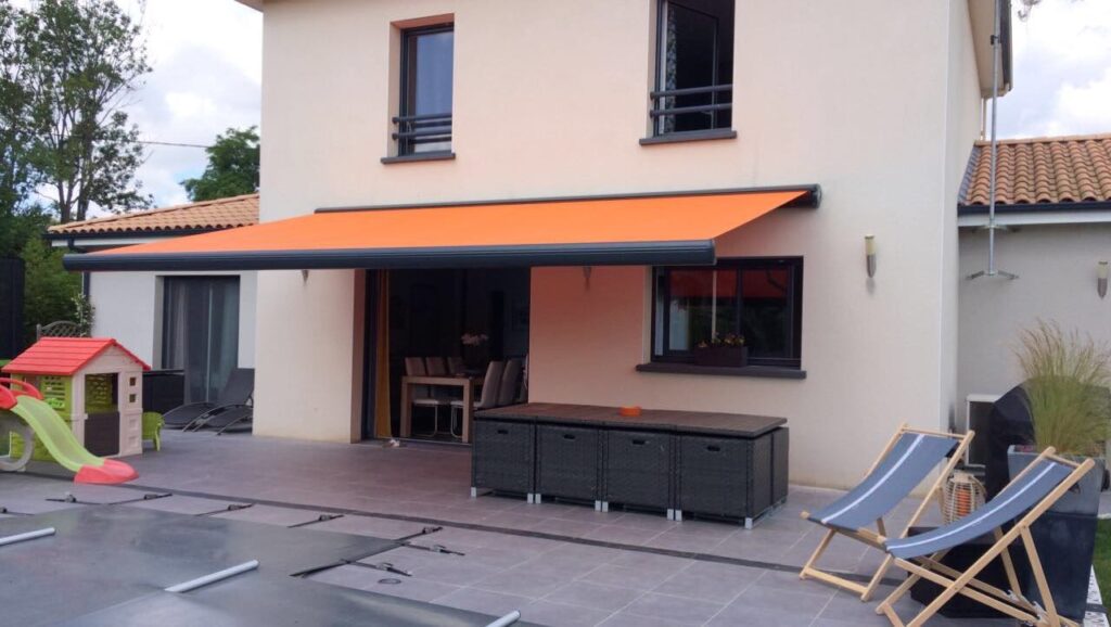 Store banne déployé au-dessus d'une terrasse carrelée, protection soleil été