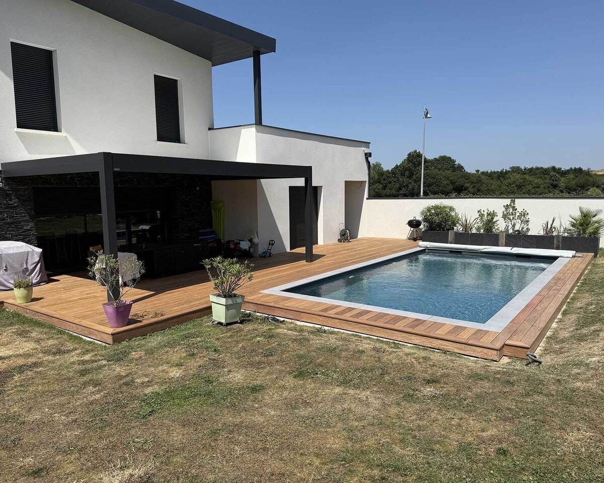 Terrasse en bois aux abords d'une piscine, prolongée par une pergola